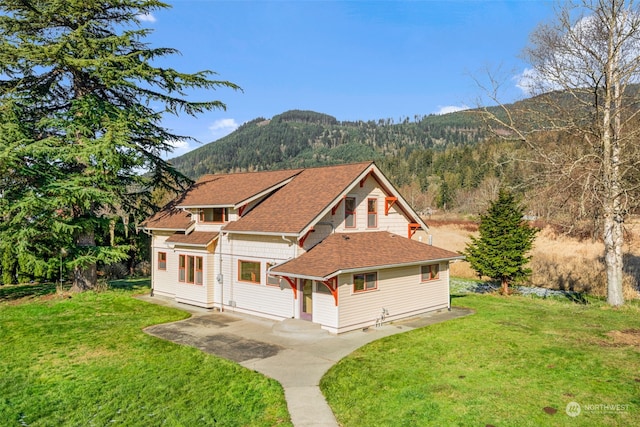 view of front of property featuring a mountain view and a front lawn