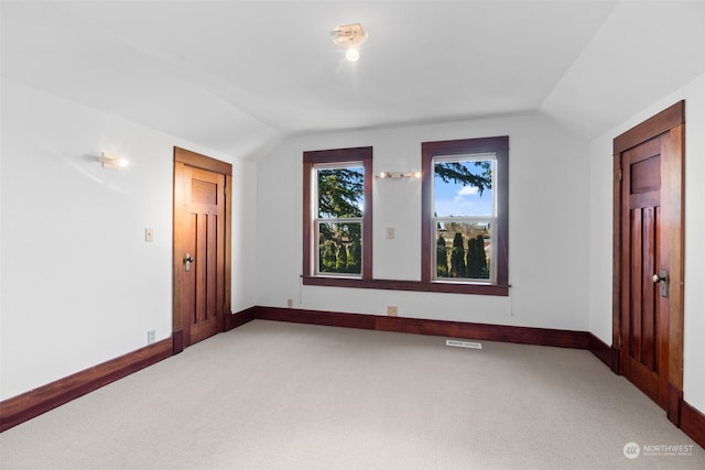 unfurnished room with lofted ceiling and carpet floors