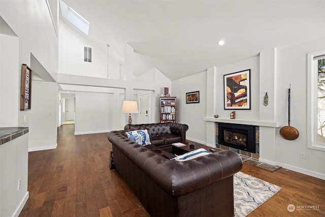 living room with dark hardwood / wood-style flooring, a fireplace, and high vaulted ceiling