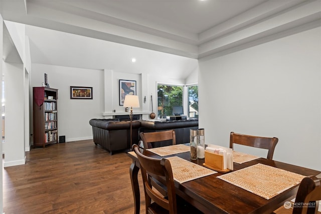 dining room with dark hardwood / wood-style floors and vaulted ceiling