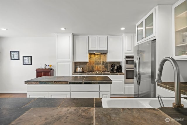 kitchen with white cabinetry, appliances with stainless steel finishes, sink, and decorative backsplash