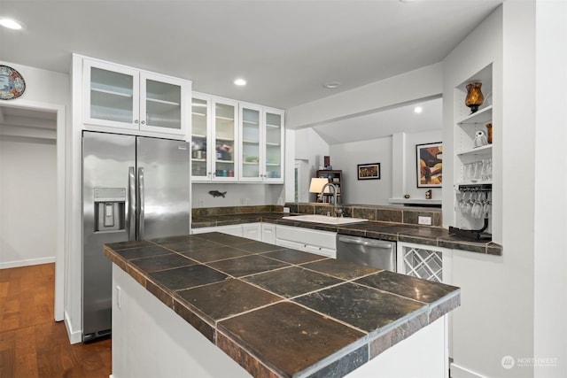 kitchen with stainless steel appliances, sink, white cabinets, and kitchen peninsula