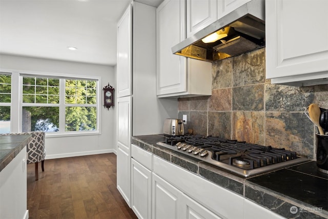 kitchen with backsplash, ventilation hood, stainless steel gas cooktop, and white cabinets