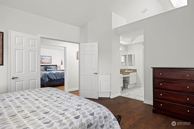 bedroom with dark hardwood / wood-style floors and ensuite bath