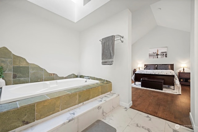 bathroom with a relaxing tiled tub and vaulted ceiling