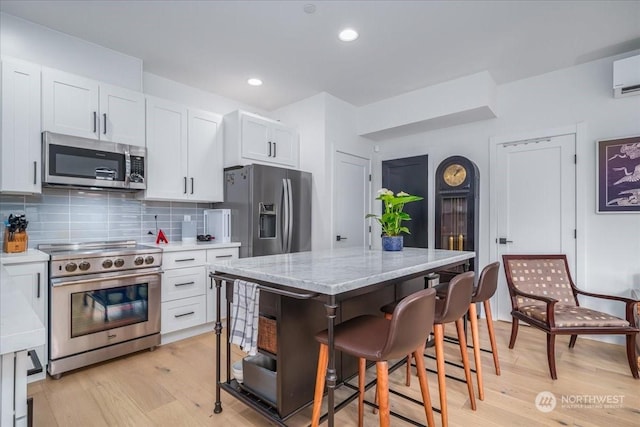 kitchen featuring white cabinetry, stainless steel appliances, and a center island with sink