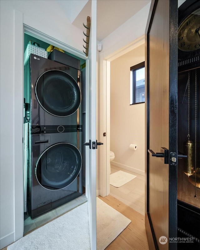 washroom featuring stacked washer / dryer and light wood-type flooring