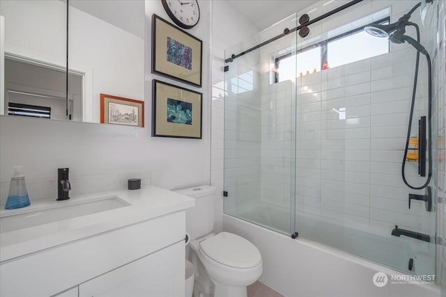 full bathroom featuring shower / bath combination with glass door, vanity, and toilet