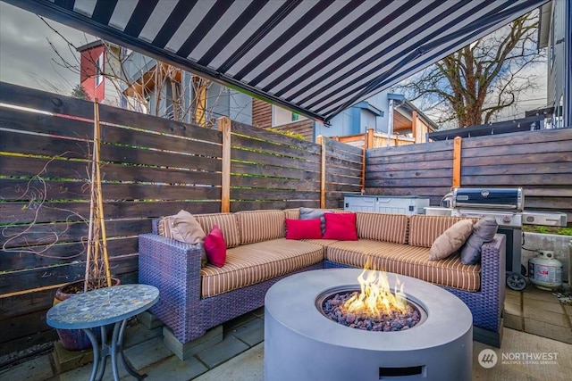 view of patio with an outdoor living space with a fire pit