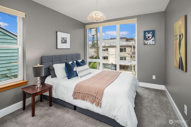 carpeted bedroom featuring multiple windows and a chandelier