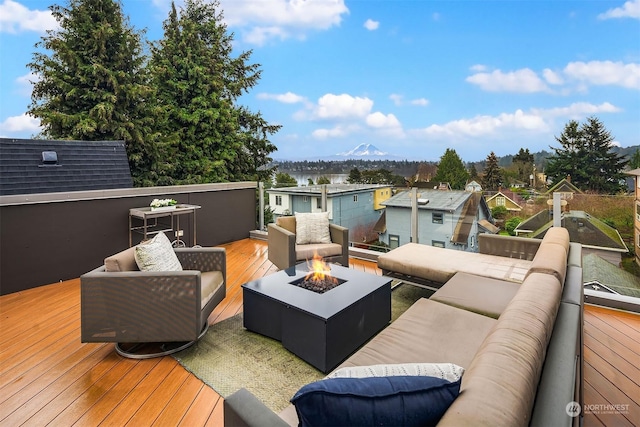 wooden deck with a mountain view and an outdoor living space with a fire pit