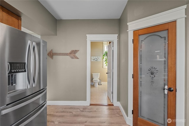 kitchen with stainless steel refrigerator with ice dispenser and light hardwood / wood-style floors