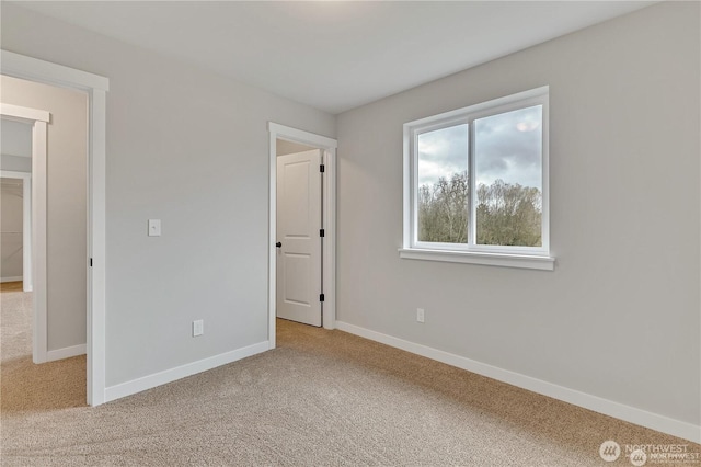 unfurnished bedroom featuring light carpet and baseboards