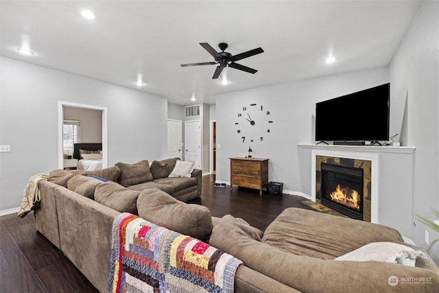 living room featuring dark wood-type flooring, a tile fireplace, and ceiling fan