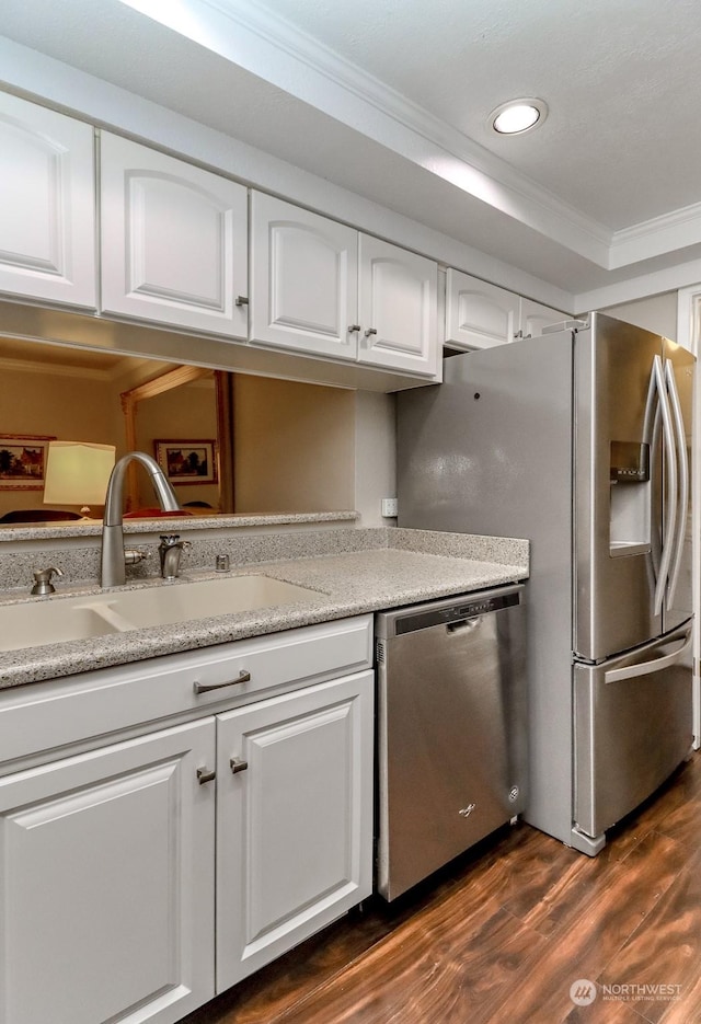 kitchen featuring sink, crown molding, dark hardwood / wood-style floors, stainless steel appliances, and white cabinets