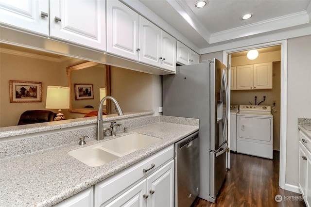 kitchen with stainless steel appliances, crown molding, washer and dryer, and white cabinets