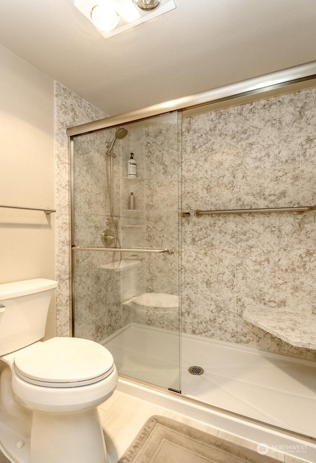 bathroom featuring walk in shower and toilet