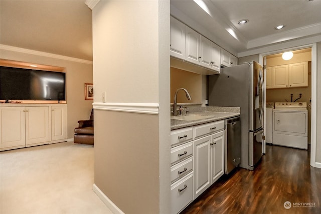 kitchen with sink, crown molding, white cabinetry, stainless steel appliances, and separate washer and dryer