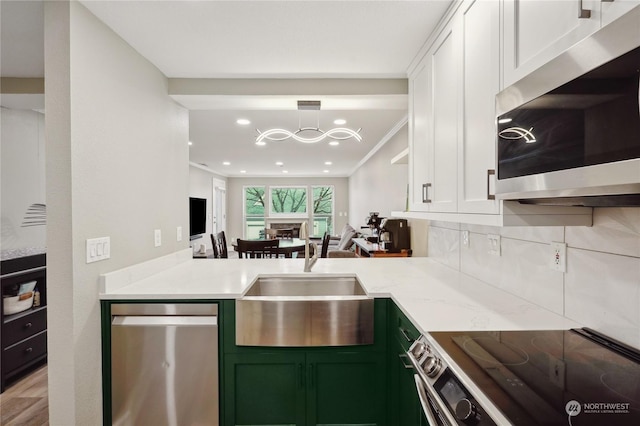 kitchen with light stone counters, sink, white cabinetry, and stainless steel appliances