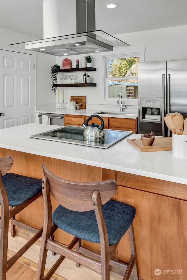 bar featuring black electric stovetop, island exhaust hood, sink, and stainless steel refrigerator with ice dispenser