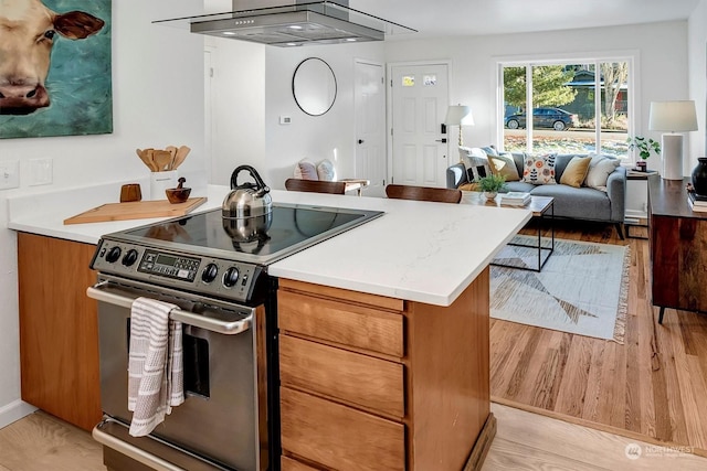 kitchen with stainless steel range with electric stovetop, range hood, and light hardwood / wood-style flooring