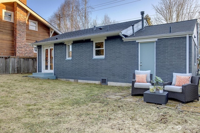 rear view of property featuring a lawn and french doors