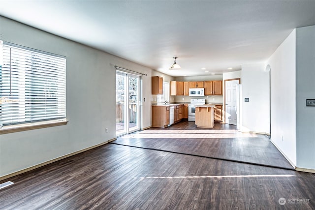 unfurnished living room featuring hardwood / wood-style flooring and sink