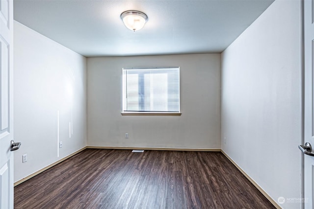 empty room with dark wood-type flooring