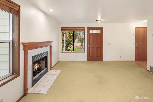 unfurnished living room featuring light colored carpet and a fireplace