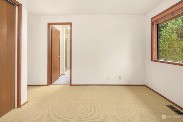 unfurnished room featuring light colored carpet