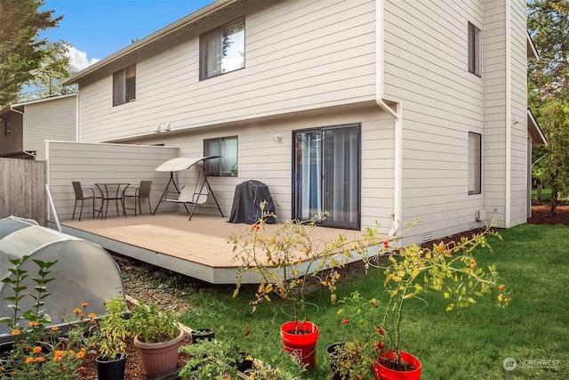 rear view of house with a yard and a deck