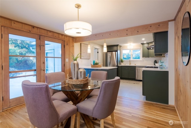 dining room with sink, french doors, and light wood-type flooring