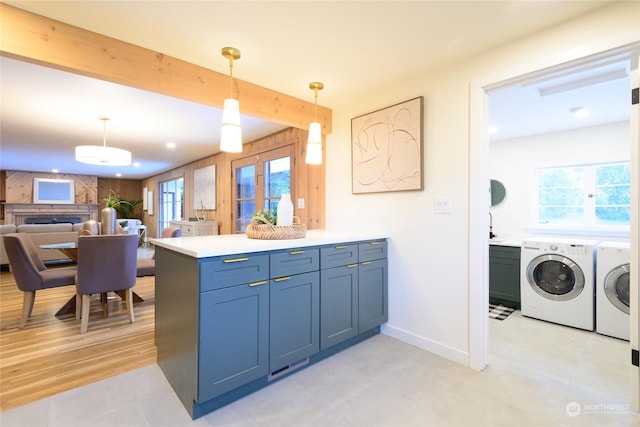 kitchen with wooden walls, hanging light fixtures, independent washer and dryer, kitchen peninsula, and beam ceiling