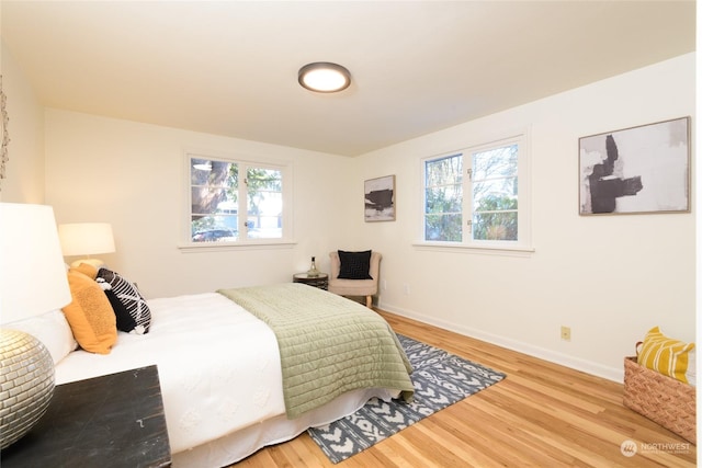 bedroom with multiple windows and wood-type flooring