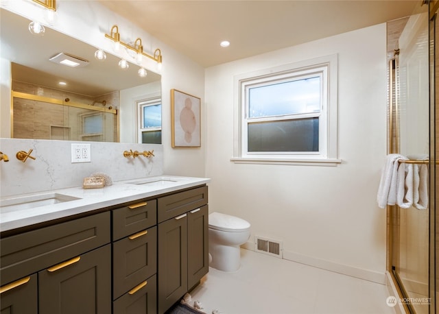 bathroom featuring vanity, a wealth of natural light, toilet, and a shower with shower door