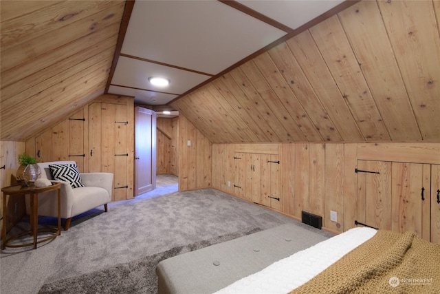 additional living space featuring lofted ceiling, light colored carpet, and wood walls