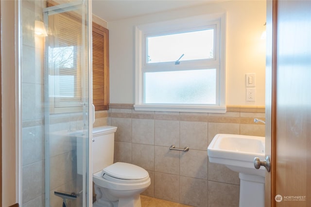 bathroom featuring tile walls, an enclosed shower, and toilet