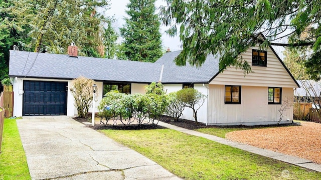 view of front of house featuring a shingled roof, concrete driveway, a chimney, an attached garage, and fence