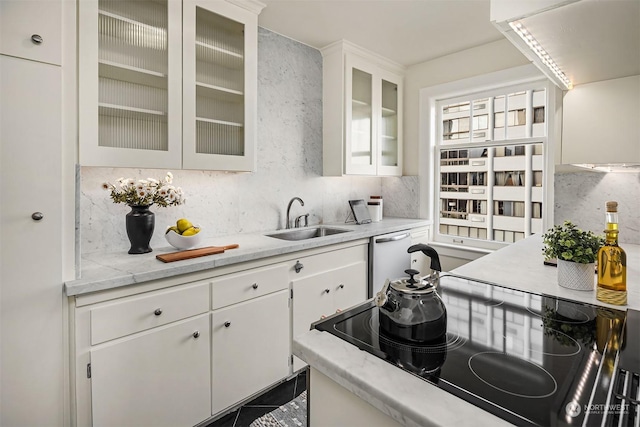 kitchen with sink, white cabinetry, dishwasher, black electric stovetop, and backsplash