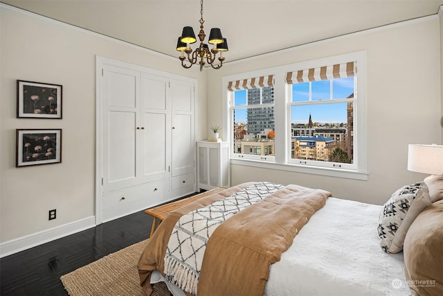 bedroom with dark hardwood / wood-style flooring, a closet, and a chandelier