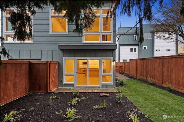 rear view of property featuring a lawn