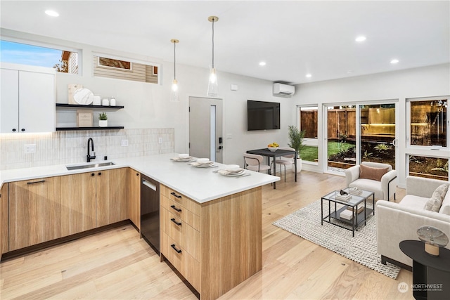 kitchen with pendant lighting, sink, stainless steel dishwasher, and kitchen peninsula