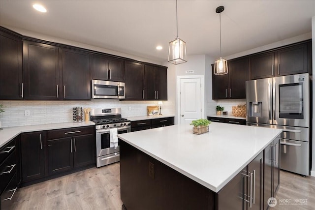 kitchen featuring hanging light fixtures, dark brown cabinets, stainless steel appliances, and a center island