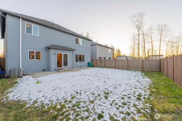 back house at dusk with central AC unit and a patio area