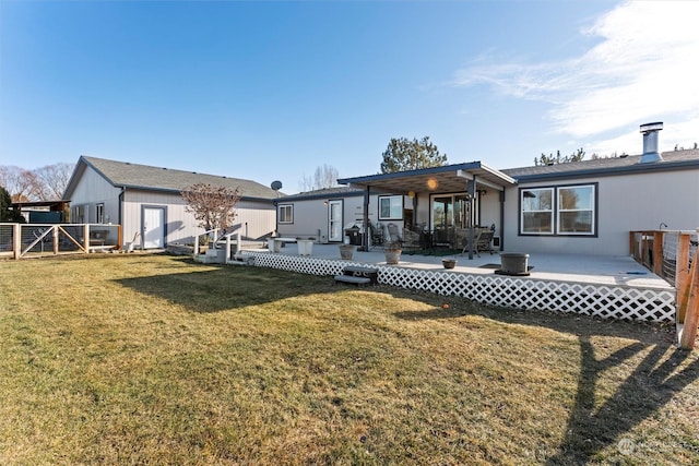 back of house featuring a wooden deck and a yard