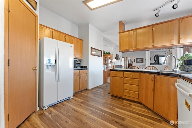 kitchen featuring tile countertops, lofted ceiling, sink, white appliances, and light wood-type flooring