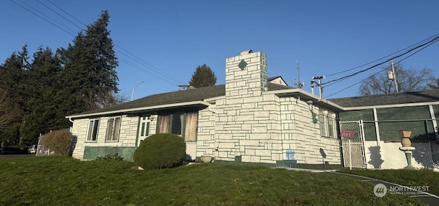 view of property exterior featuring a lawn and a sunroom