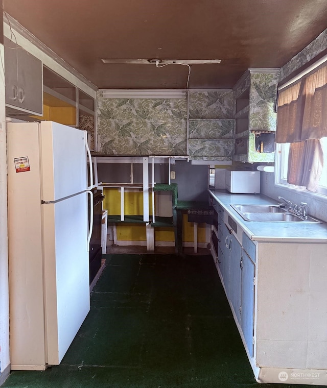 kitchen featuring sink and white fridge