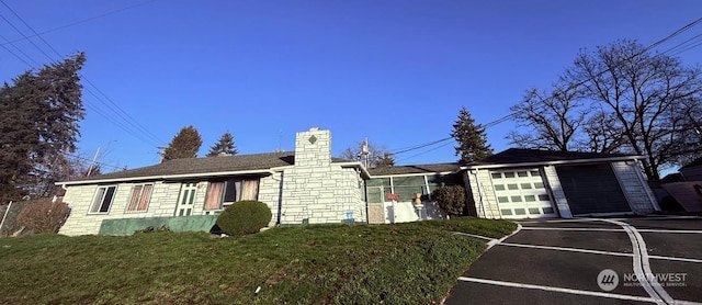 view of front of home with a garage, an outdoor structure, and a front lawn