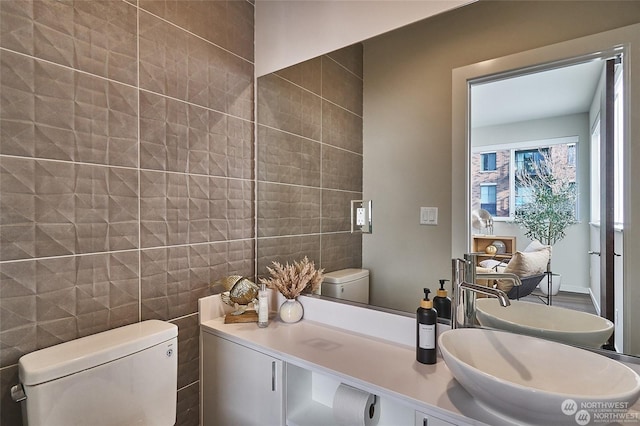 bathroom featuring tile walls, vanity, and toilet